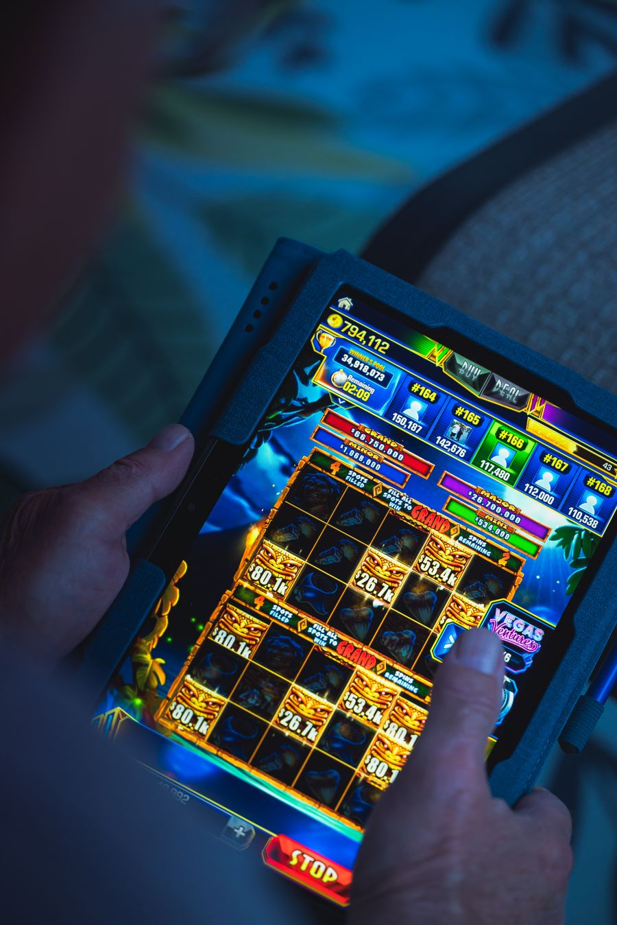 Tangan memegang ponsel saat bermain game mobile