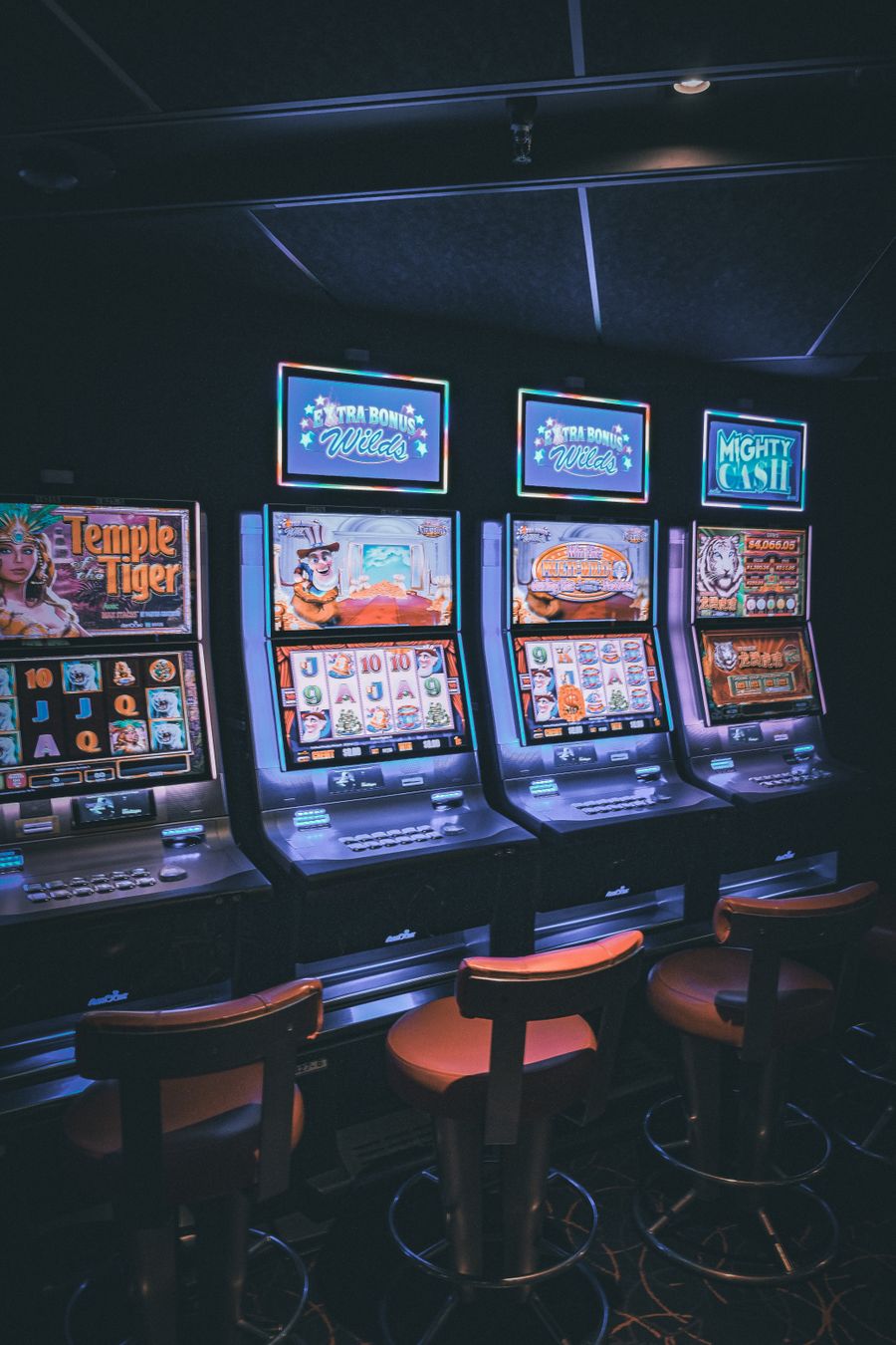 Deretan mesin slot bercahaya di lantai kasino